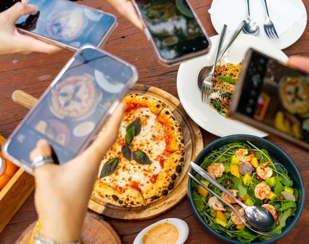 Group of friends taking pictures of their food at a restaurant wifi enabled location. - Datavalet - Datavalet